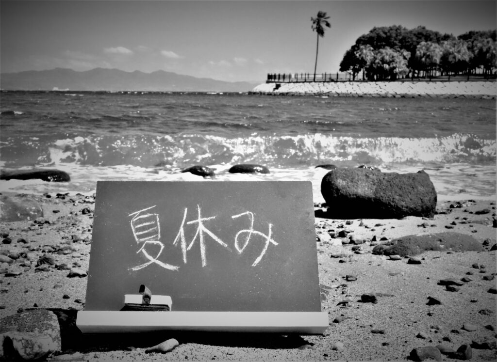 Japanese beach in old times with a blackboard written `Summer Vacation'