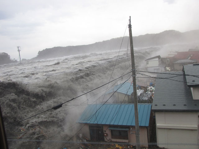 Tsunami waves flooding homes in a coastal town during the 2011 Great East Japan Earthquake