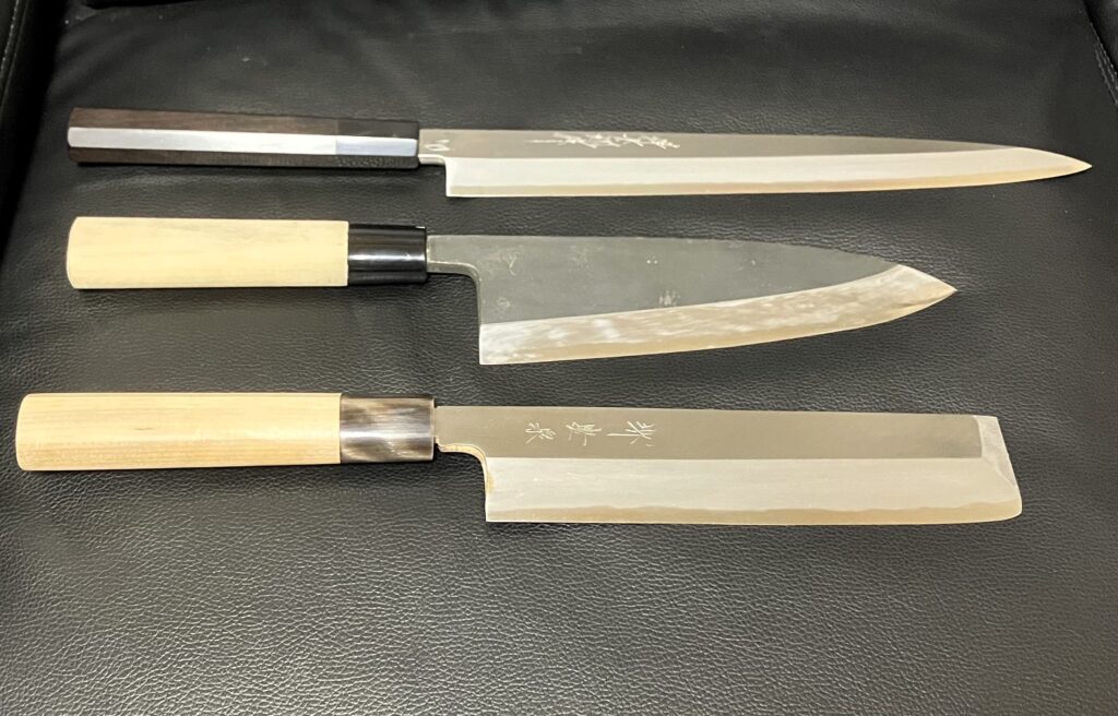 Three Japanese kitchen knives with long, broad and rectangular blades